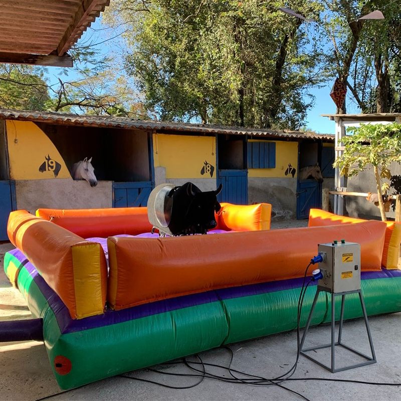 Touro mecânico Boi Bandido montado em um haras, com baias amarelas ao fundo